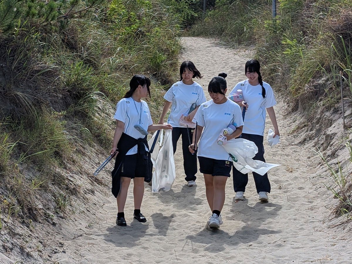 庄内砂丘の防砂林周辺にてゴミ拾いする酒田南高校の生徒たち