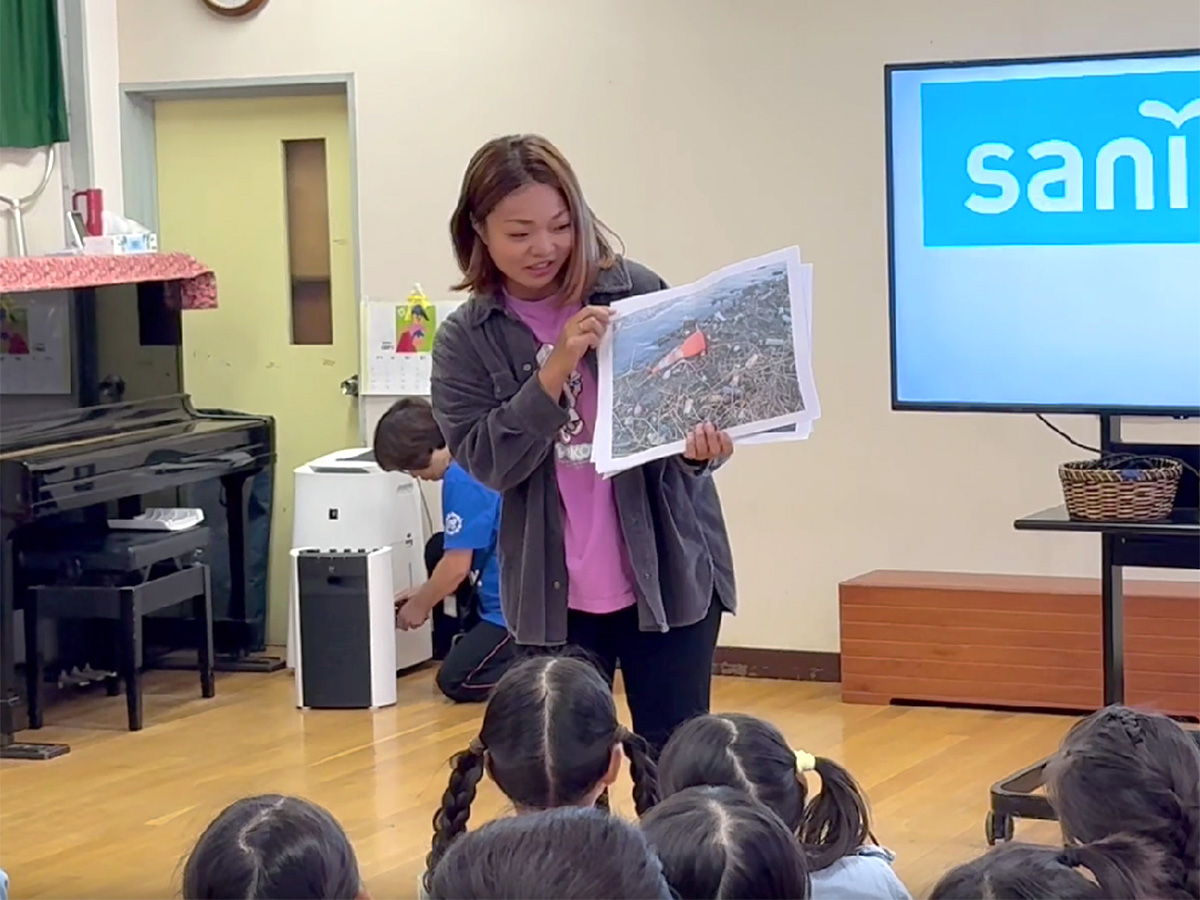 ゴミがたくさん漂流している写真を見せる臨川小学校教員の鈴木先生