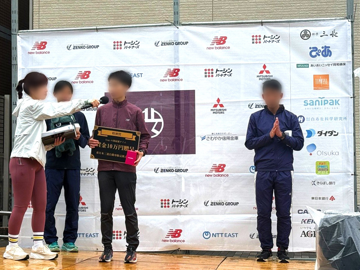 入賞選手がインタビューを受けるステージに掲出されたサニパックロゴ（中央右端）