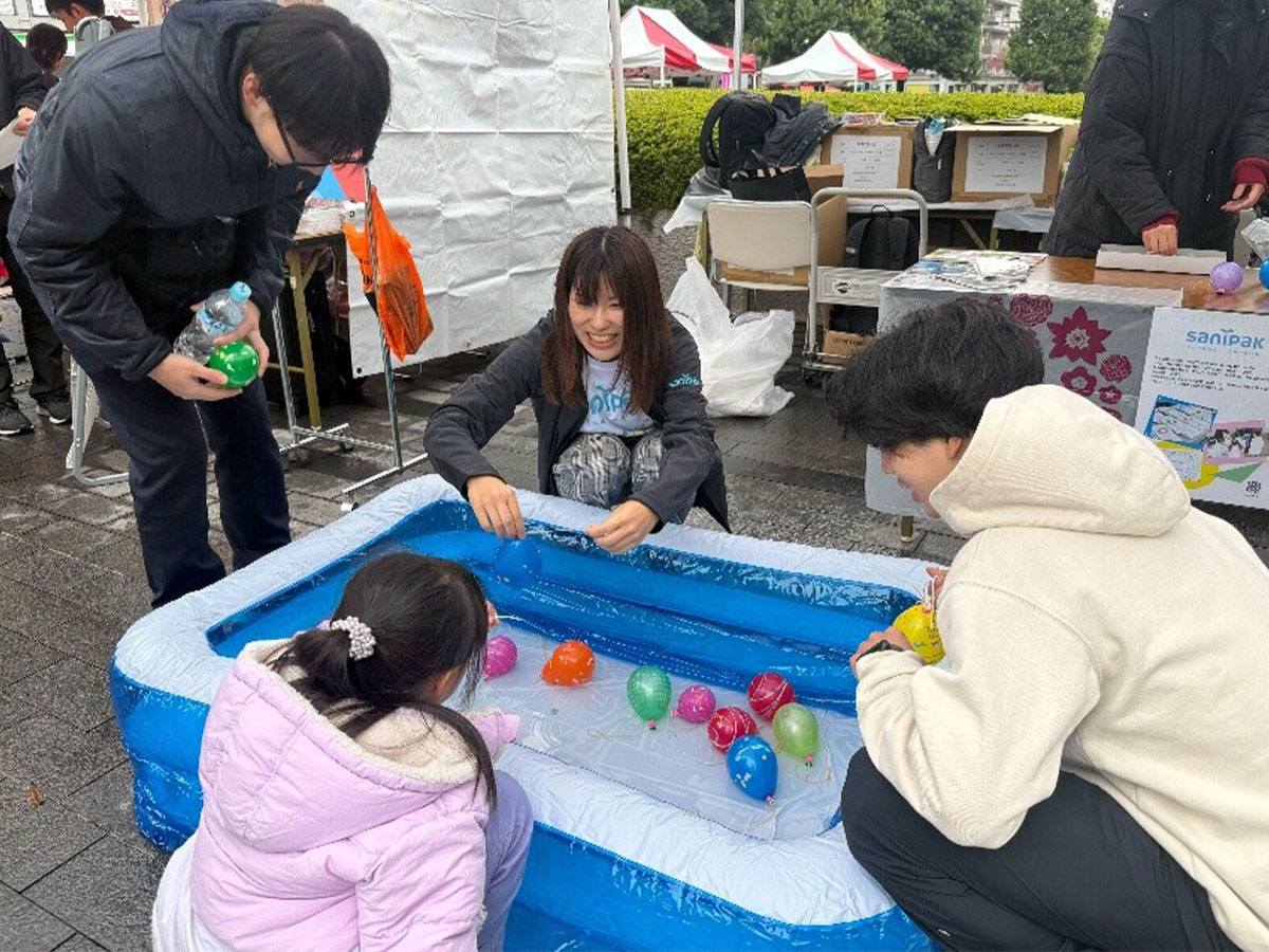 釣れた水ヨーヨーをプレゼントするサニパック社員