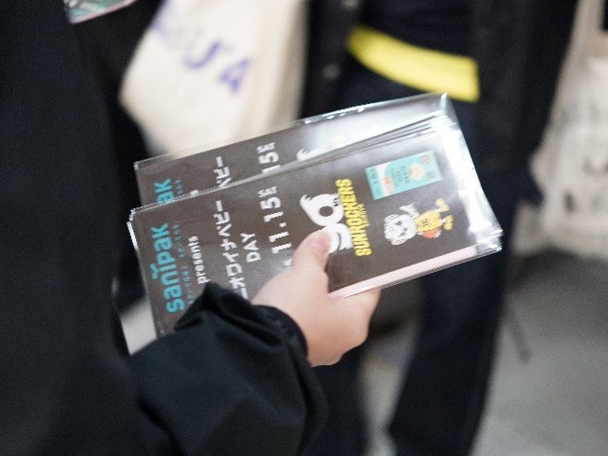 入場ゲートで消臭ポリ袋「ニオワイナベビー」のサンプルを配布する様子